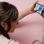 Une femme tient un smartphone affichant un visage analysé par un maillage numérique bleu, illustrant l'authentification et l'analyse visuelle par IA.
