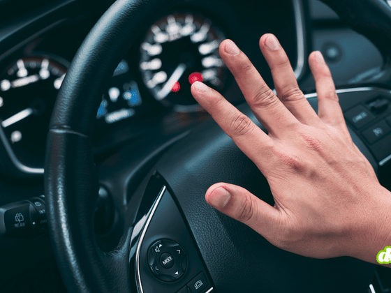 Main d'un conducteur appuyant sur le volant d'un véhicule, illustrant le vol de millions de permis de conduire lié à IDScan.