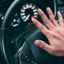 Main d'un conducteur appuyant sur le volant d'un véhicule, illustrant le vol de millions de permis de conduire lié à IDScan.