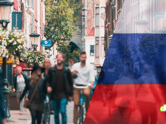 Rue commerçante européenne avec des passants, superposée au drapeau russe, illustrant les opérations en zone grise en Europe.