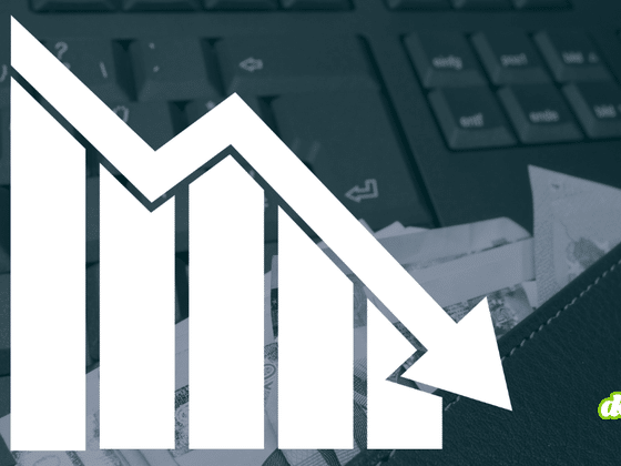 Graphique en barres avec flèche descendante sur fond de clavier d'ordinateur et de billets de banque, illustrant la chute des paiements de rançons après une attaque de ransomware
