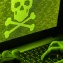 Mains gantées sur un ordinateur portable affichant du code vert et une tête de mort, illustrant la cyberattaque de ShinyHunters contre le groupe Clop.