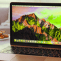 Ordinateur portable Apple MacBook ouvert affichant le bureau de macOS sur une table, illustrant le système d'exploitation et ses paramètres de sécurité Full Disk Access.