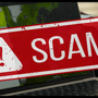 Ordinateur portable affichant une cartographie et estampillé d'un tampon d'alerte rouge avec la mention SCAM