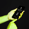 Mains tenant un smartphone affichant un écran d'authentification par empreinte digitale sur fond noir.