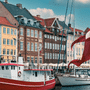 Drapeau danois flottant devant les façades colorées et les bateaux amarrés sur un canal de Copenhague.