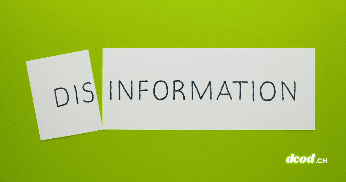 Sur un fond vert vif, une feuille de papier blanche a été coupée en deux, séparant le mot « DISINFORMATION » écrit en lettres capitales noires. Le petit morceau de gauche, légèrement incliné, porte l'inscription « DIS », tandis que le grand morceau de droite affiche « INFORMATION ».