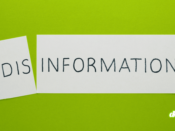 Sur un fond vert vif, une feuille de papier blanche a été coupée en deux, séparant le mot « DISINFORMATION » écrit en lettres capitales noires. Le petit morceau de gauche, légèrement incliné, porte l'inscription « DIS », tandis que le grand morceau de droite affiche « INFORMATION ».