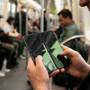 Gros plan sur un smartphone pliable tenu en main, montrant une fissure prononcée et un pli marqué au centre de l'écran intérieur éteint.