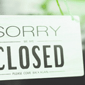 Panneau suspendu avec l'inscription « Sorry we are closed », illustrant le blocage de l'accès aux sites marchands pour les agents d'intelligence artificielle.