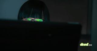 Pirate informatique observant un écran dans l'obscurité avec des reflets verts sur ses verres de lunettes, illustrant le vol de données du FBI par ShinyHunters.