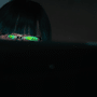 Pirate informatique observant un écran dans l'obscurité avec des reflets verts sur ses verres de lunettes, illustrant le vol de données du FBI par ShinyHunters.